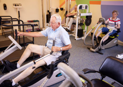 residents exercising on sitting elliptical machines in the taylor glen fitness room